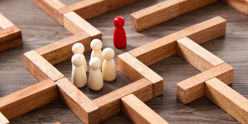 Wooden miniature at the start point of puzzle maze wood block. L Leadership concept.Wooden miniature at the start point of puzzle maze wood block